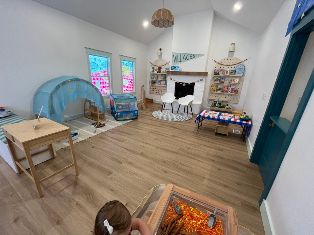 Wide view of the Villages Clubhouse indoor play area with themed activity setups.