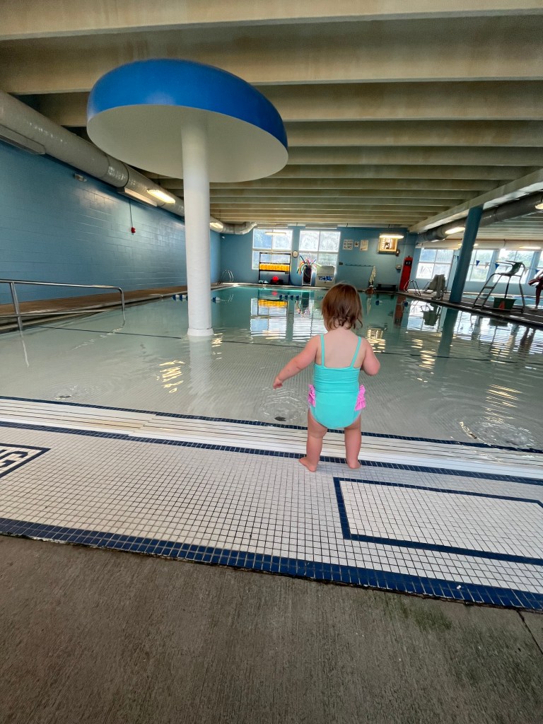 Toddler standing at the edge of an indoor pool in Columbia, Tennessee.