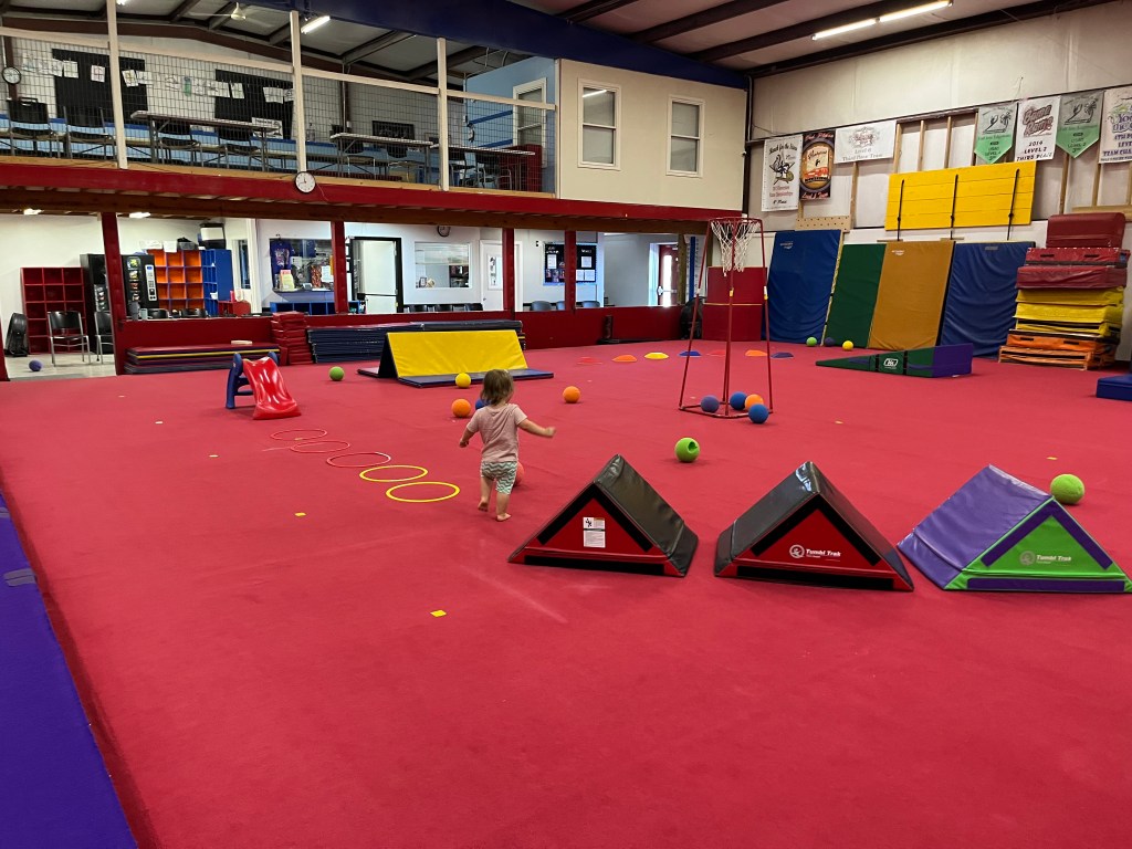 A toddler exploring the equipment during open gym at Discovery Gymnastics in Columbia, Tennessee.