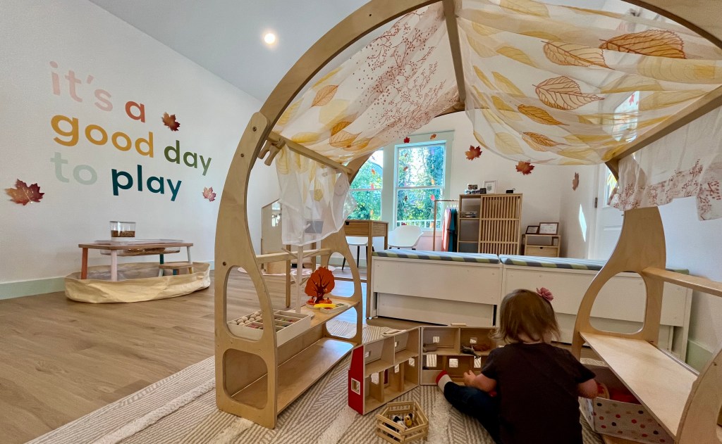 Child playing inside Villages Clubhouse in Columbia TN beneath a sign that says “It’s a good day to play,” representing the family activities featured in the Weekly Guide on Columbia TN Kids Guide.